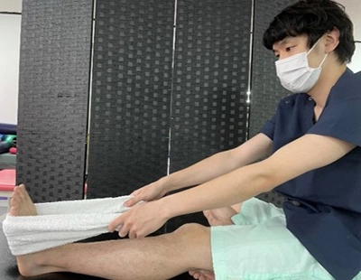 タオルを用いて、足関節を上に反りストレッチ