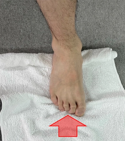 タオルを用いて、足関節を上に反りストレッチ